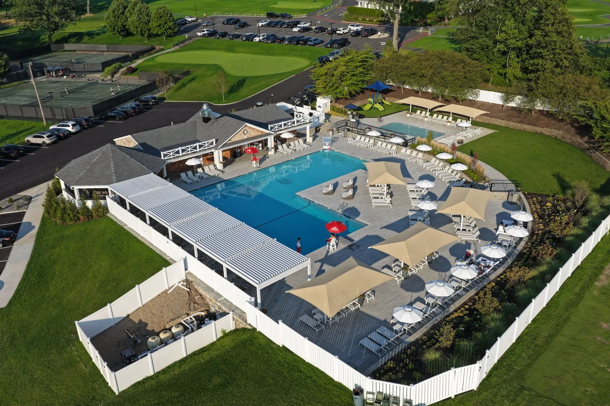 Sponzilli’s completed Essex County Country Club poolside transformation, with expanded patios, shaded dining, lounge seating, and surrounding landscape.
