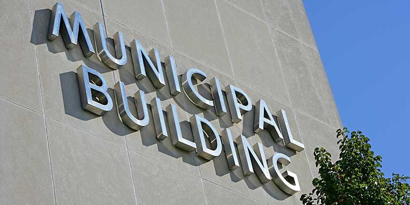 imposing wall of gray Municipal Building with sign in metal letters