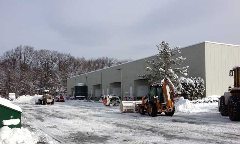 Snow removal equipment clearing a snow-covered parking lot