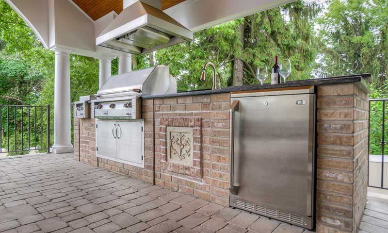 Beautiful outdoor kitchen with built-in refrigerator, grill, and sink