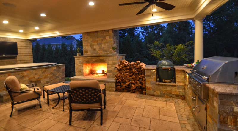 Outdoor entertaining space with fireplace and outdoor kitchen and hot tub