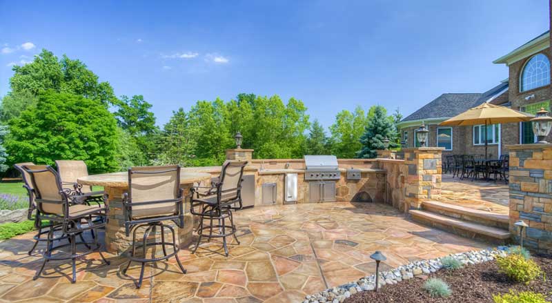 A multi-tiered patio with two separate outdoor entertaining spaces
