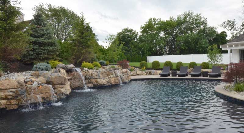Small boulders accent a large backyard swimming pool
