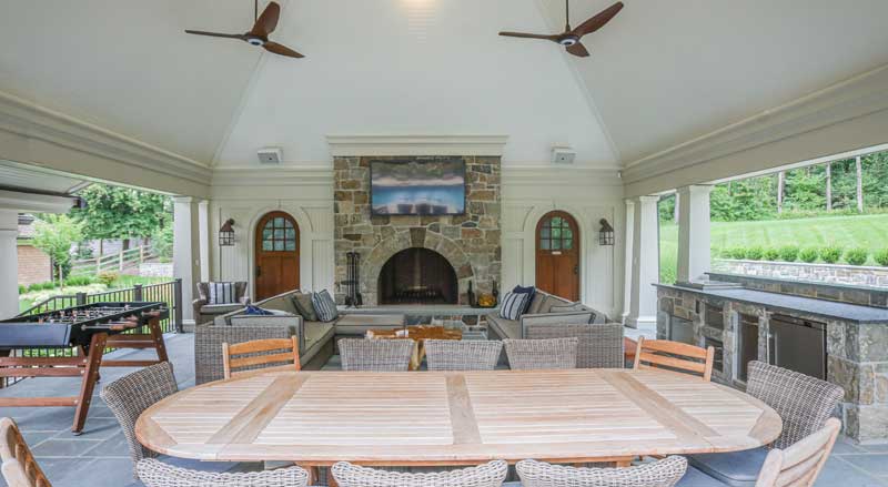 Pavilion with kitchen, dining area, fireplace, and large seating area for outdoor living