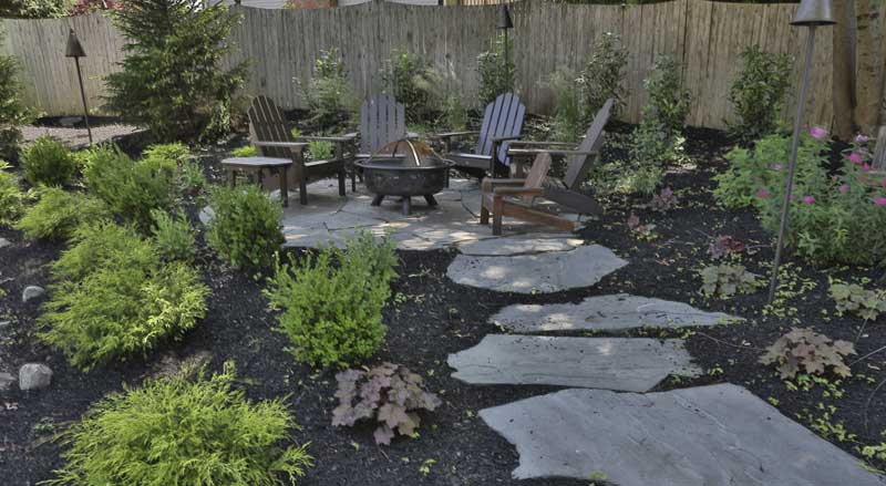 Large stepping stones leading to a circular patio with firepit