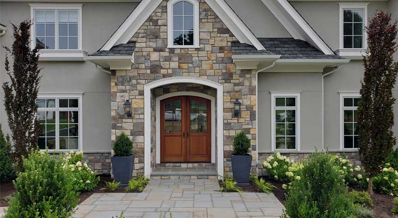 A stone entryway to a beautiful colonial style home