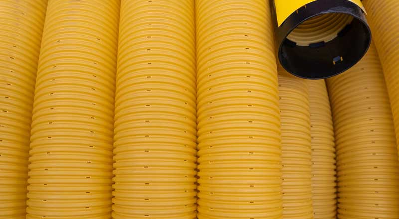 Rows of yellow perforated flexible pipe used for drainage solutions