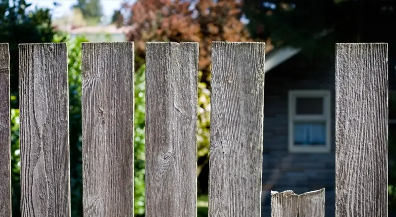Closeup of a worn wooden fence with a broken slat