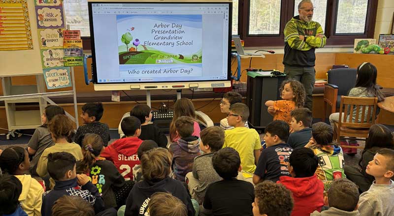 Students watch a live presentation about Arbor Day