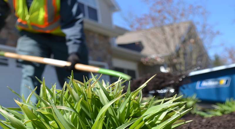 A Sponzilli worker plants new flowers at an HOA community