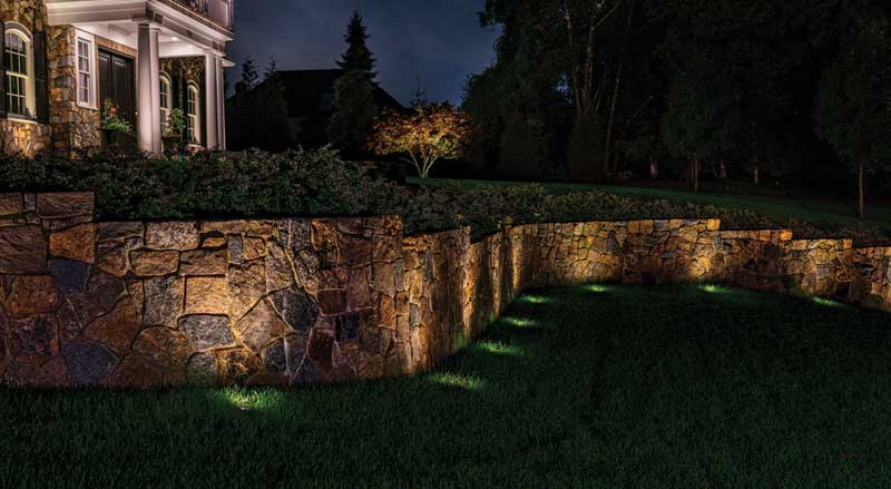 Stone retaining wall with uplighting to showcase its features