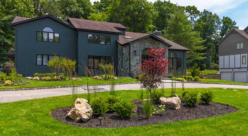 a green, lush front yard with professionally landscaped garden bed