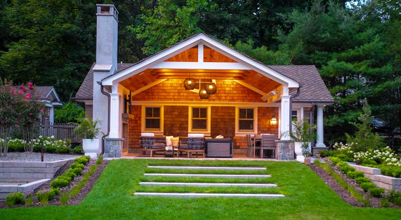 Cozy backyard pavilion with wood ceiling, hanging lights, and inviting seating area—creating a warm and functional outdoor living space
