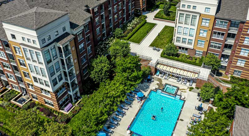 Residential community pool area surrounded by professionally maintained landscaping