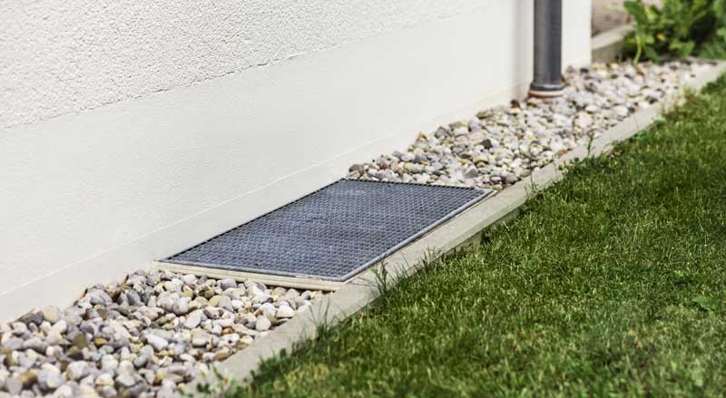 Foundation drainage system with gravel and drain cover designed to direct water away from home