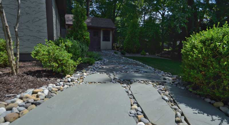 Stone walkway with gravel borders designed for water runoff and drainage control