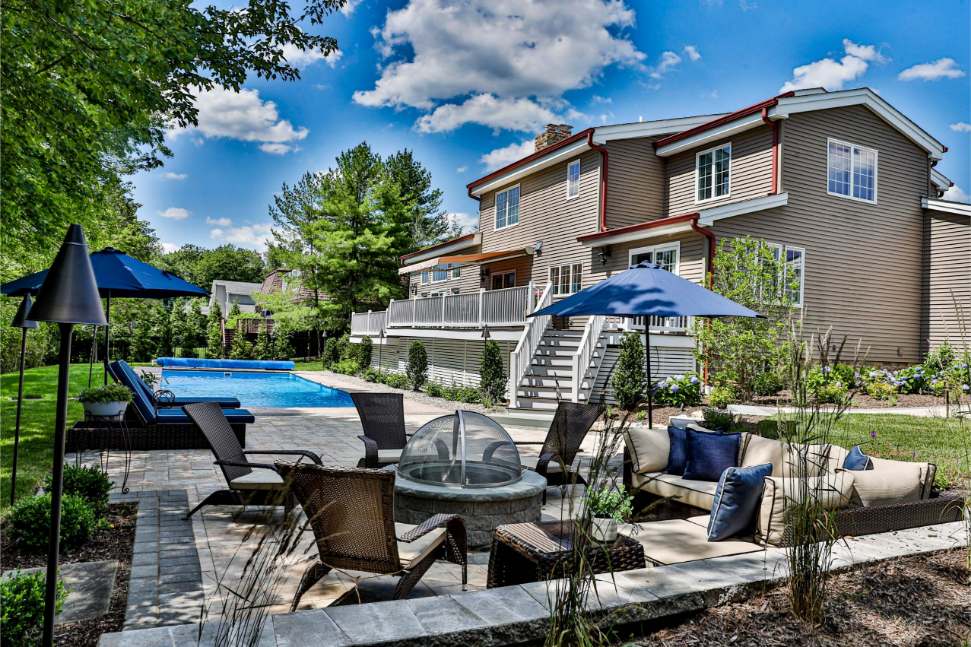 Luxury poolscape with stone patio and outdoor seating