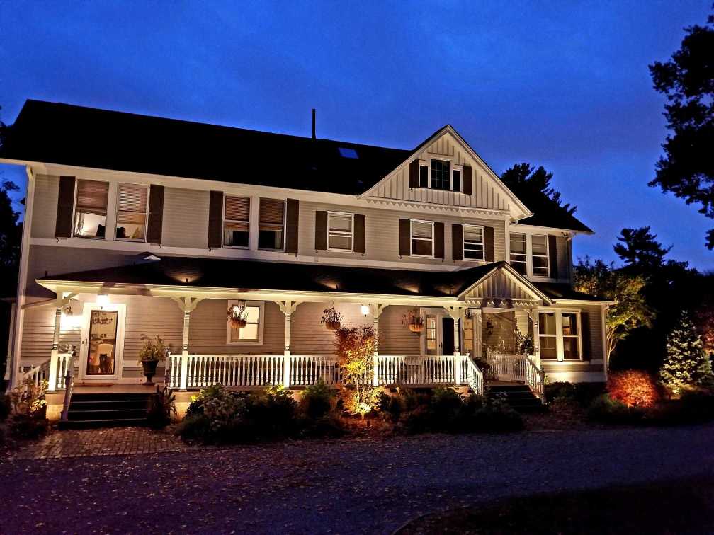Night view of front landscape with architectural and garden lighting