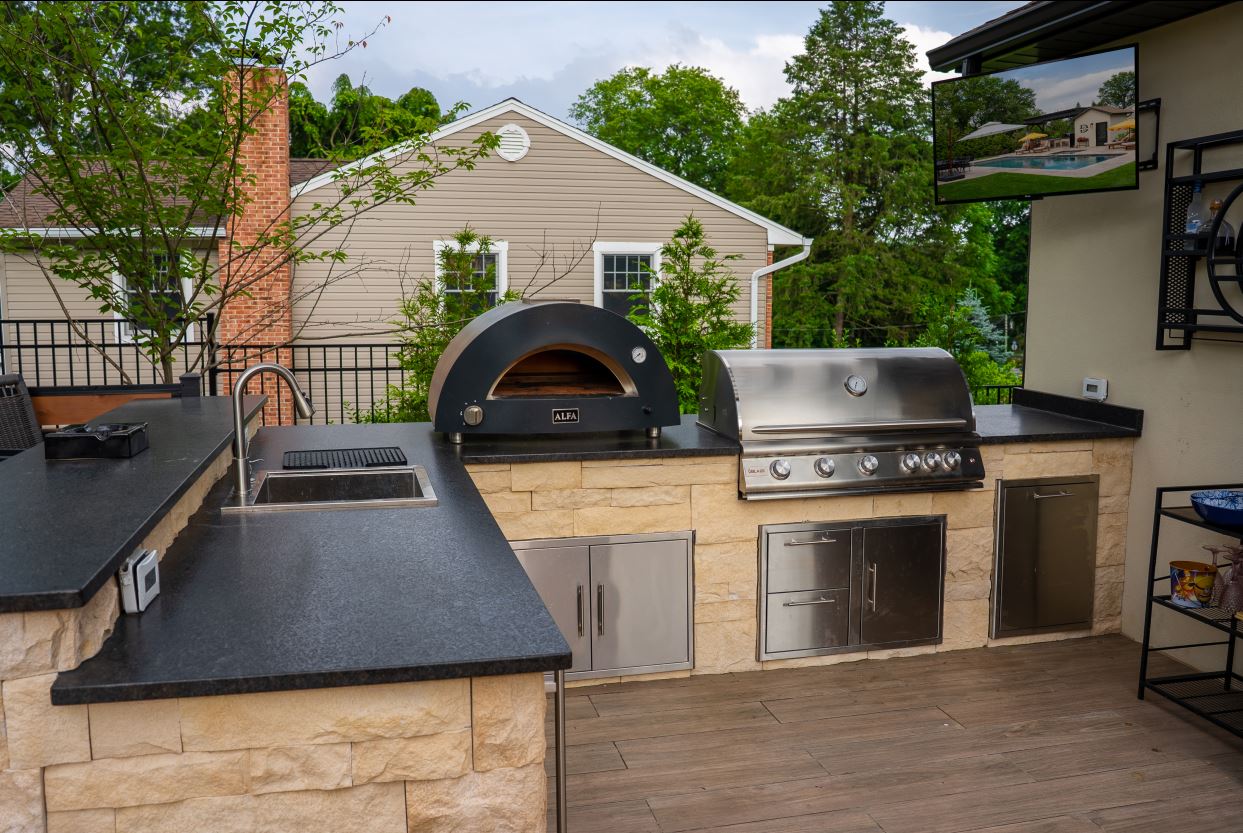 Outdoor kitchen with pizza oven, built-in television and audio system for entertaining