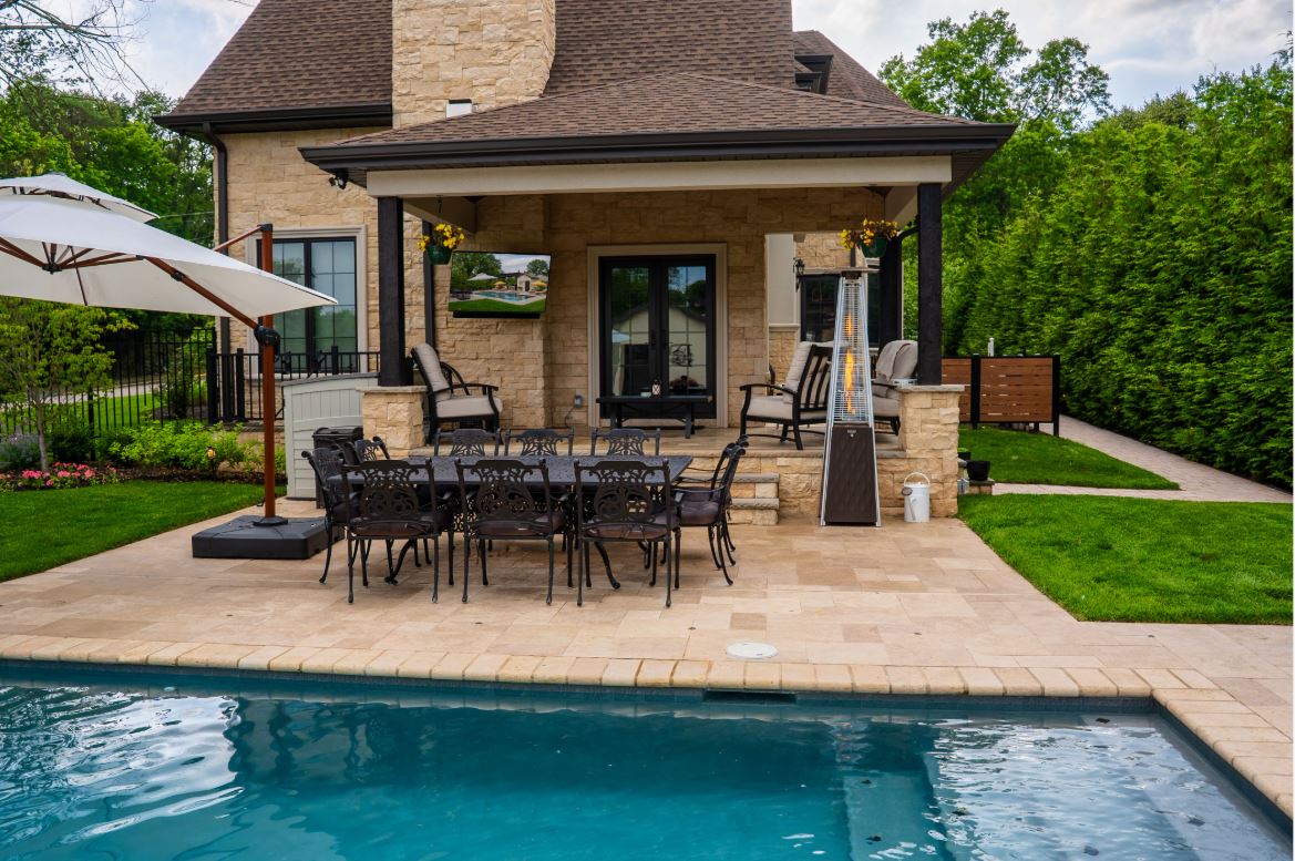 Poolside dining area under a covered pavilion with outdoor TV and audio