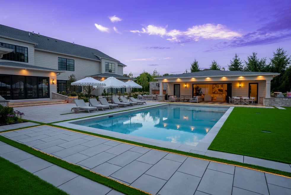 Custom pool landscape with modern patio, pool house, outdoor lighting, and landscaped grounds in Northern New Jersey